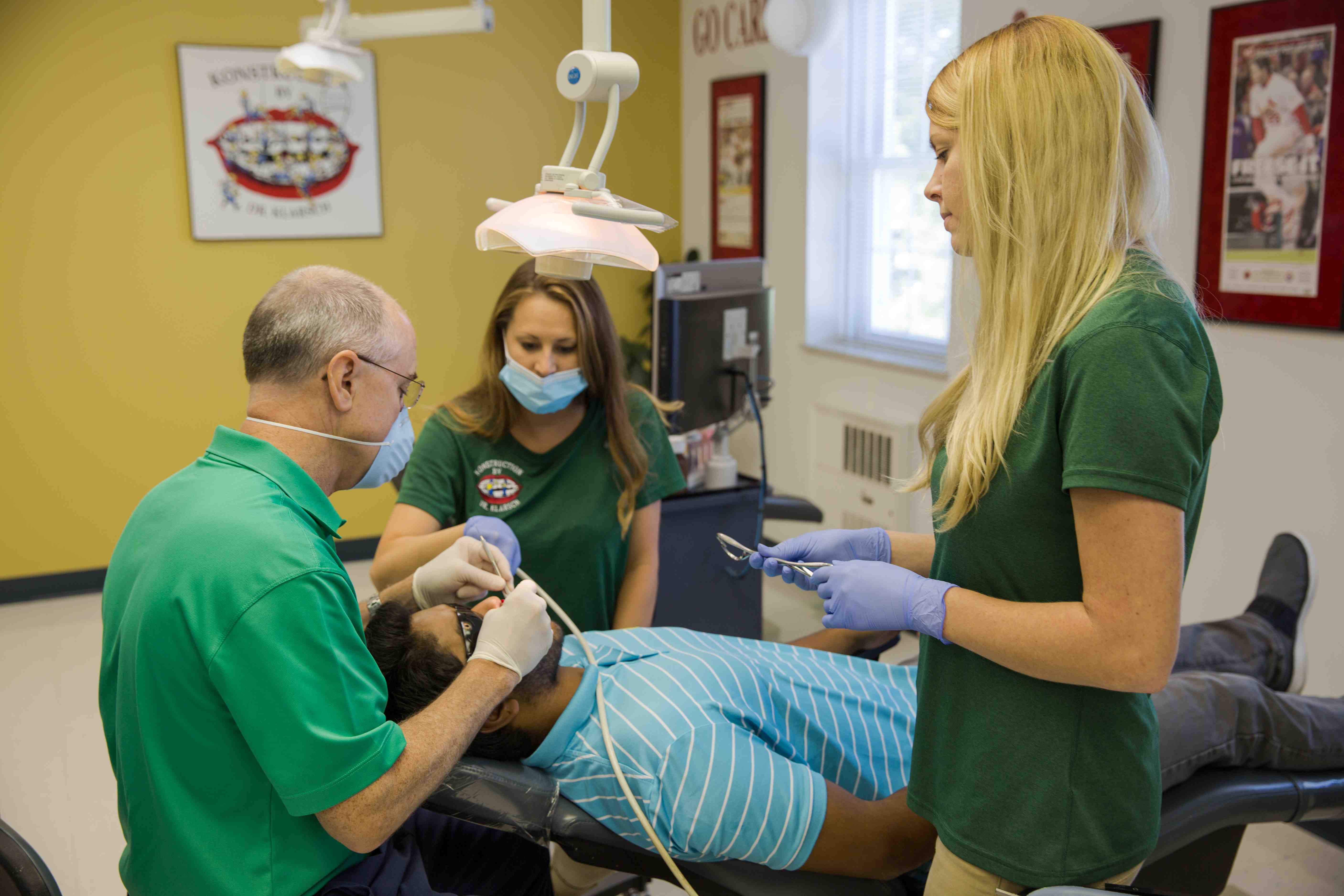 Orthodontist and two assistances working on a patient during a checkup.