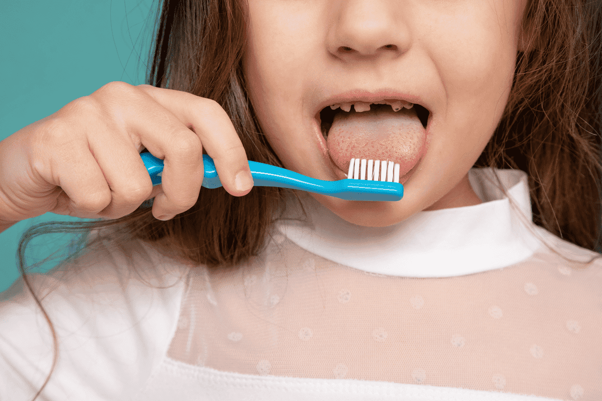 Child brushing her teeth, demonstrating when it may be appropriate to start phase 1 treatment, with a mixed dentition.